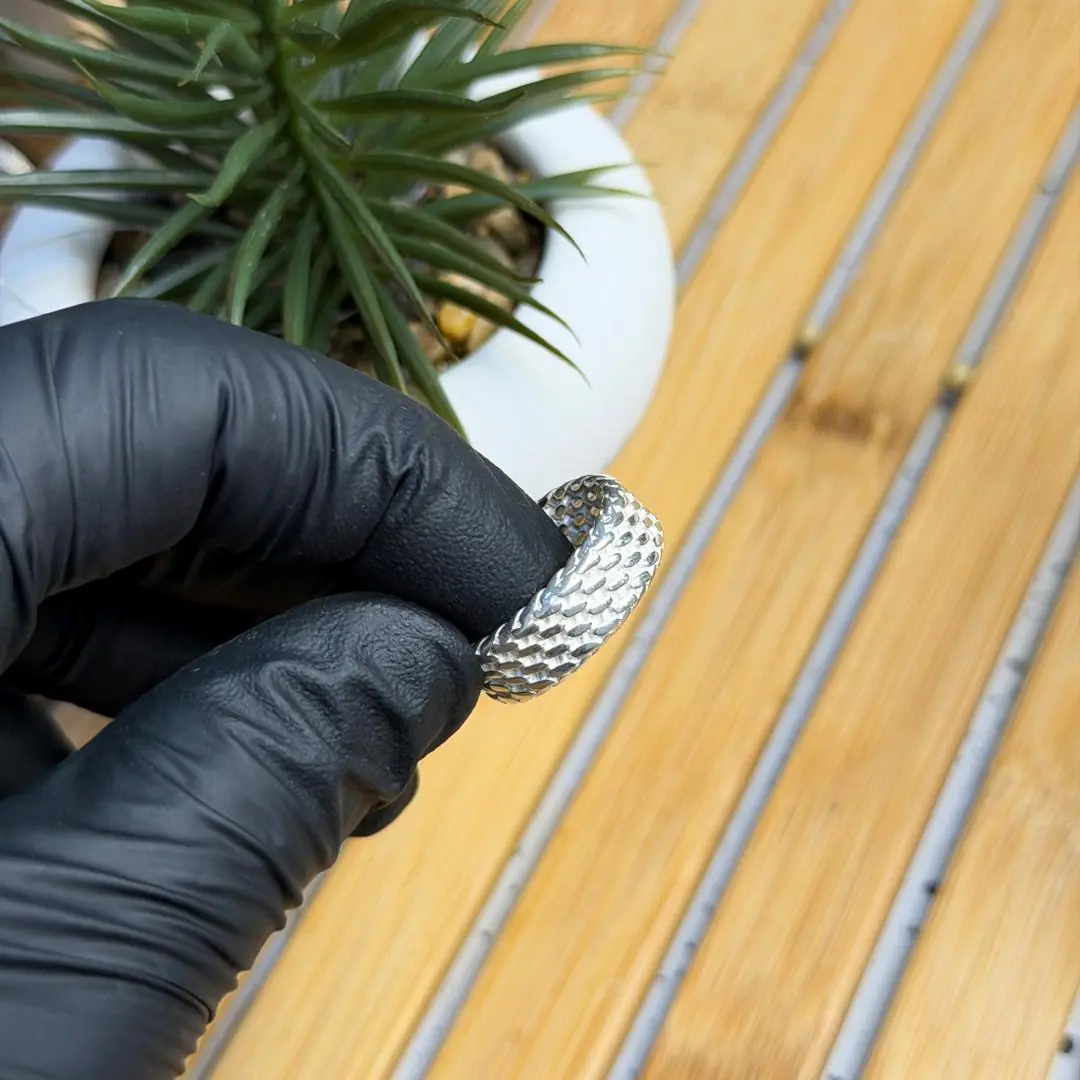 Bague sertie présentée à la main avec gant noir