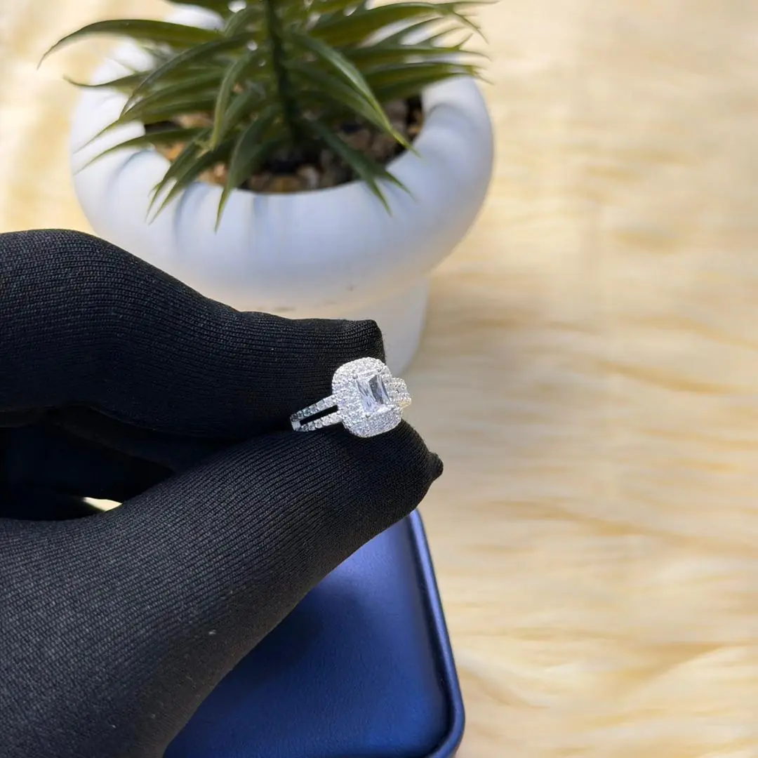 Bague sertie de profil sur main gantée et écrin bleu